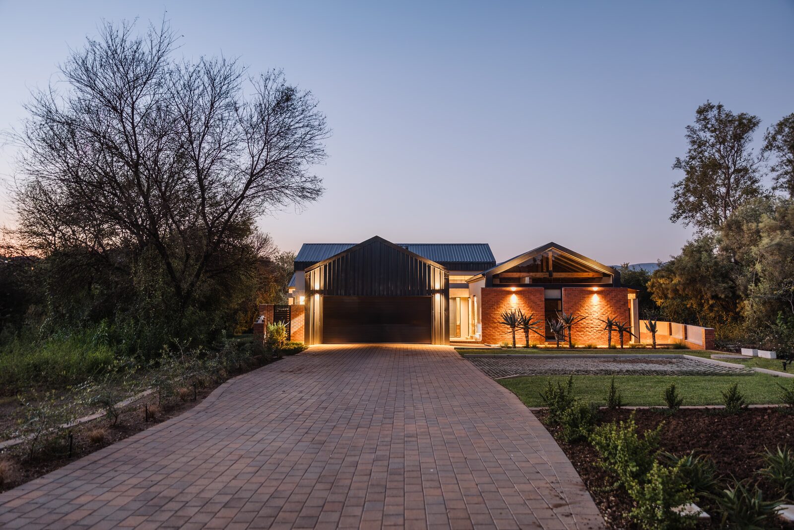 Exterior view of Landsmeer House — modern farm-style home in red face brick, steel and glass in Landsmeer Estate, Hartbeespoort, designed by Aloe Studio Architects